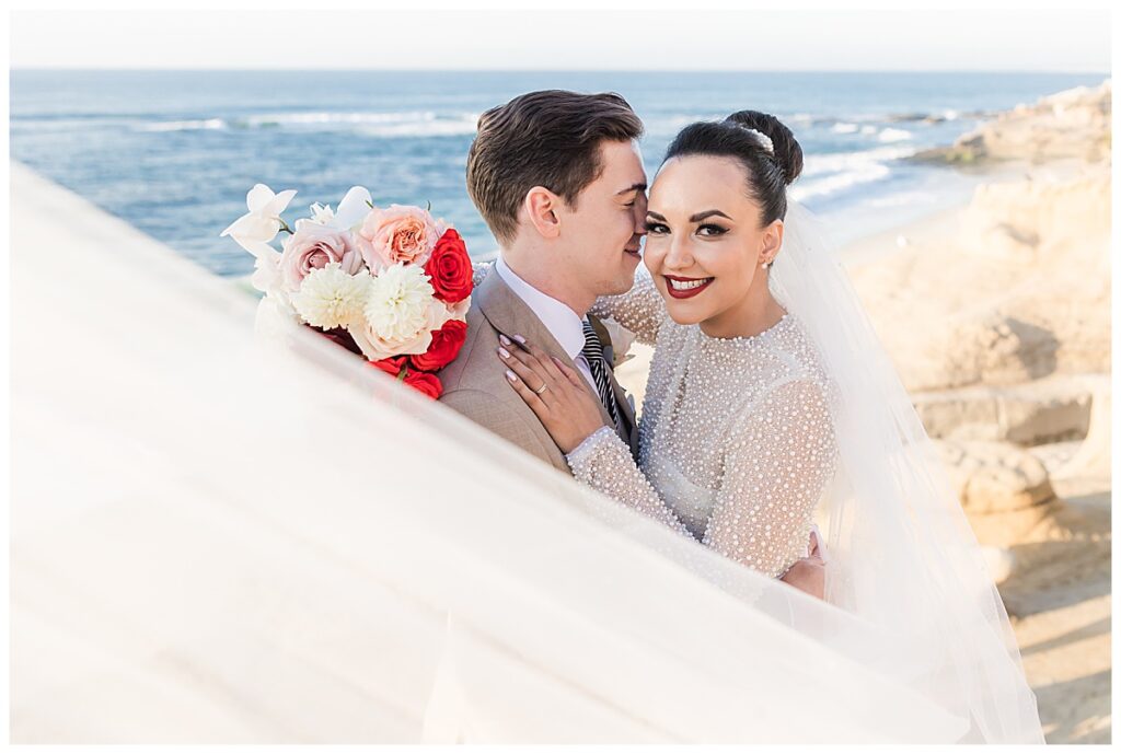 bride and groom with swooping veil at the cliffs in La Jolla San Diego