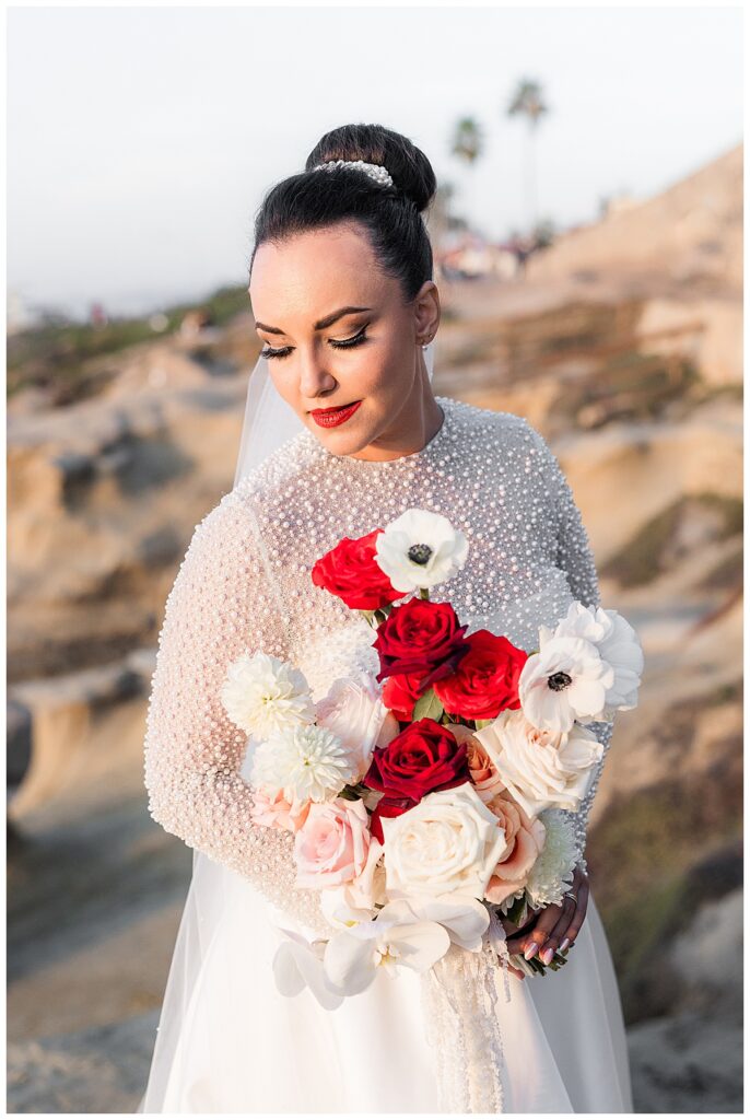bride with red and white bouquet at the cliffs in La Jolla San Diego