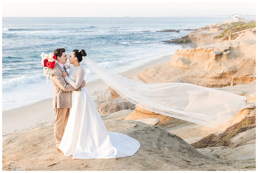 bride and groom with flying veil at the cliffs in La Jolla San Diego