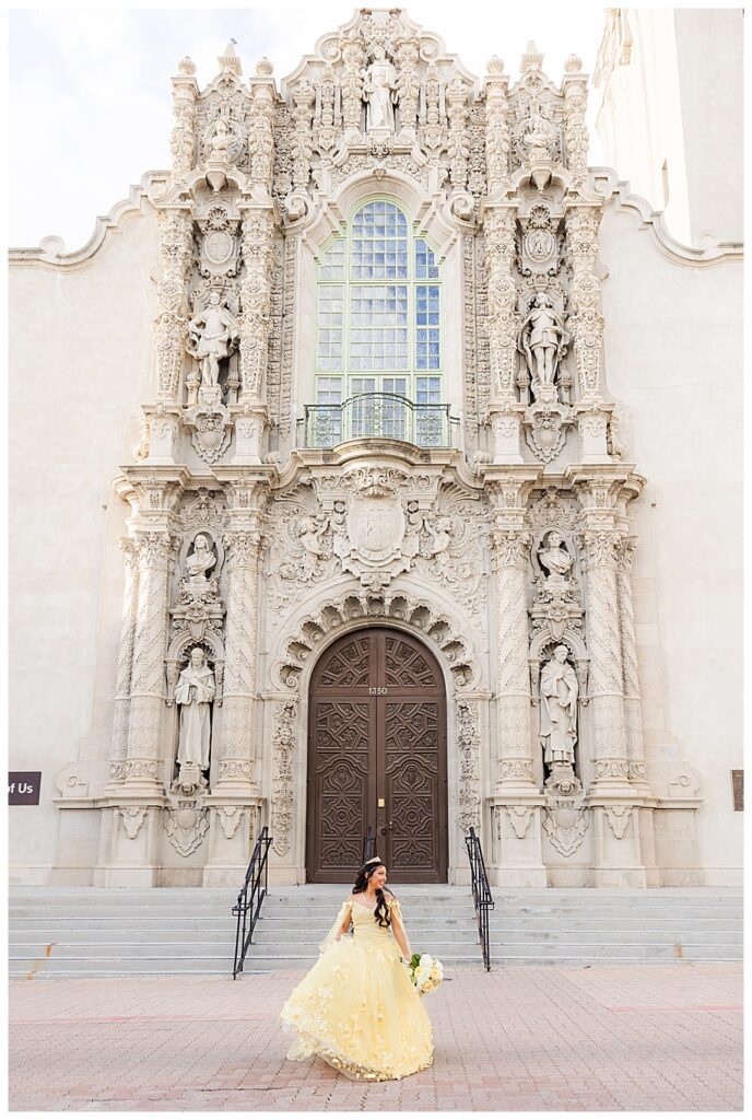 Teen girl in yellow dress in front of the Museum of Man for her Balboa Park Quinceanera photo shoot