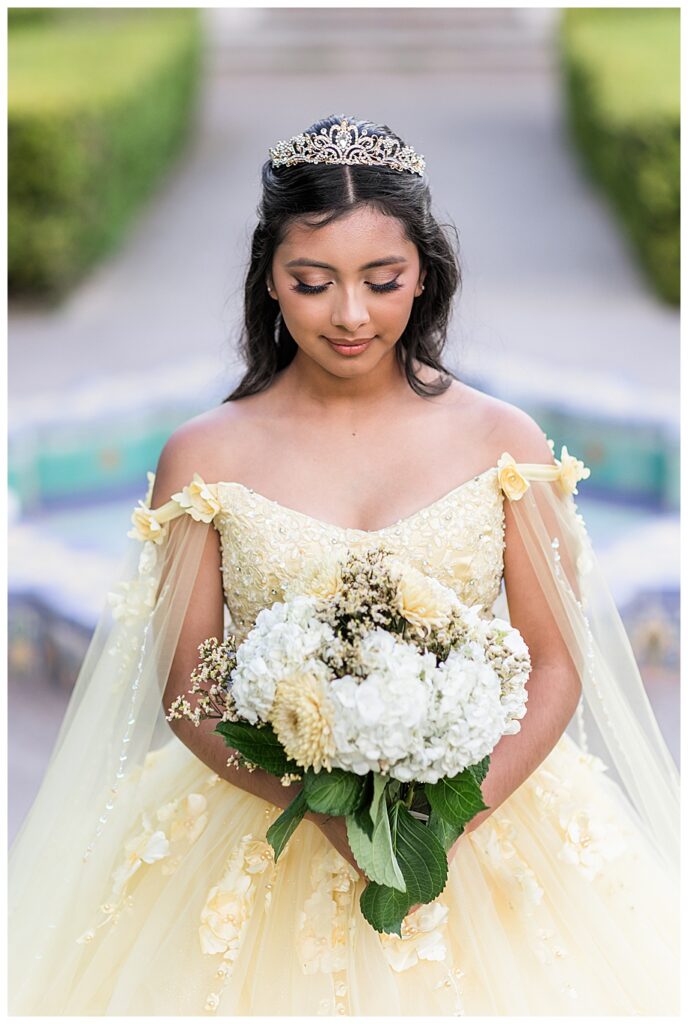 Balboa Park Quinceanera portrait of teen girl in yellow dress and tiara with a bouquet