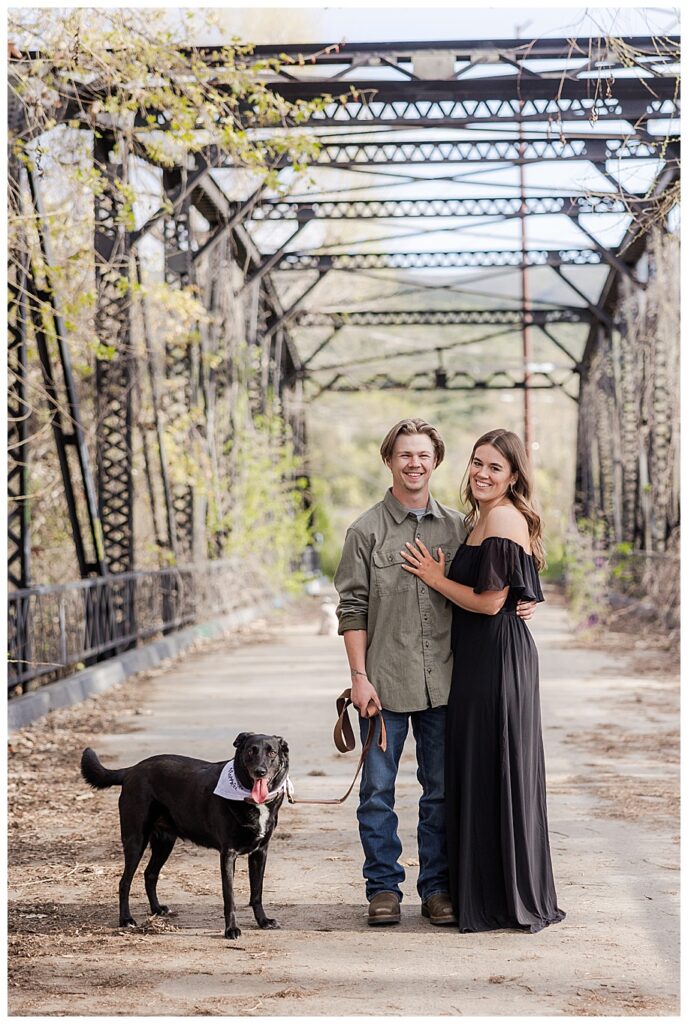 couple standing on Sweetwater River Bridge with their dog
