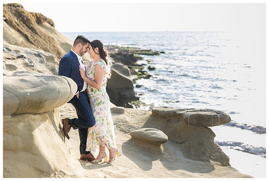 couple leaning against the cliffs at their La Jolla Cliffs Engagment Session
