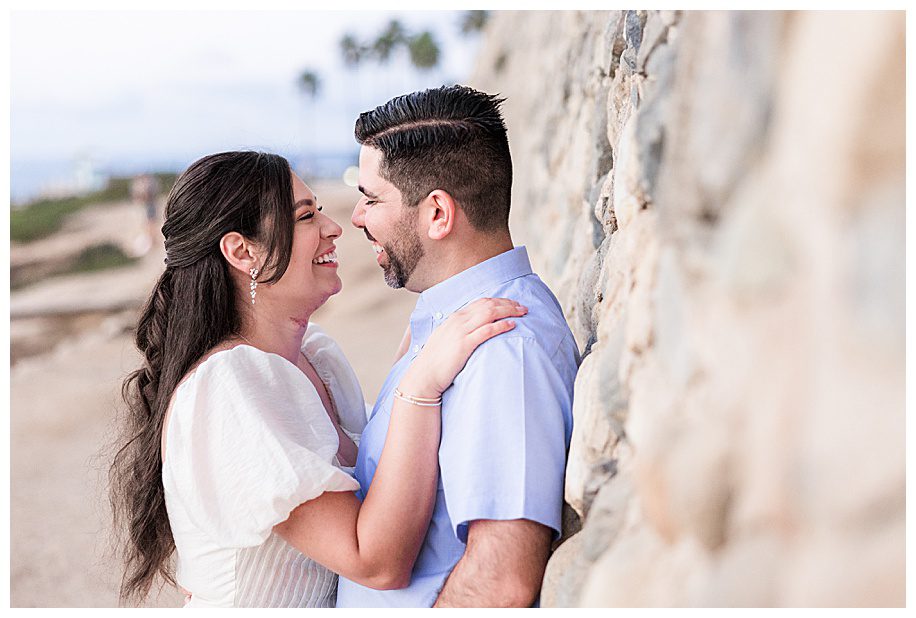couple leaning against wall and smiling