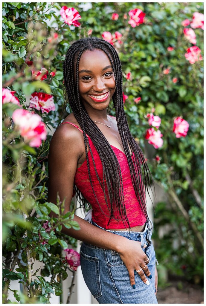 senior girl standing in roses