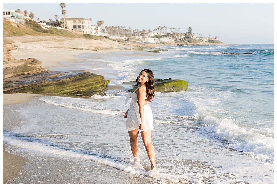girl running away down beach at her  Windnsea senior session