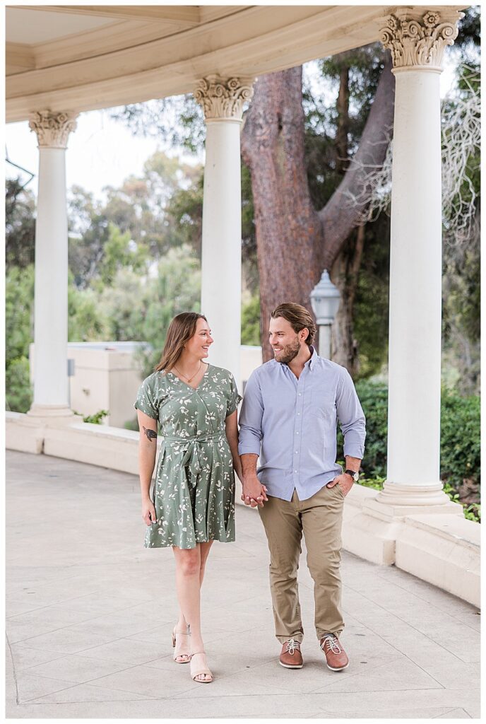 Couple walking in organ pavilion at engagement session at Balboa Park
