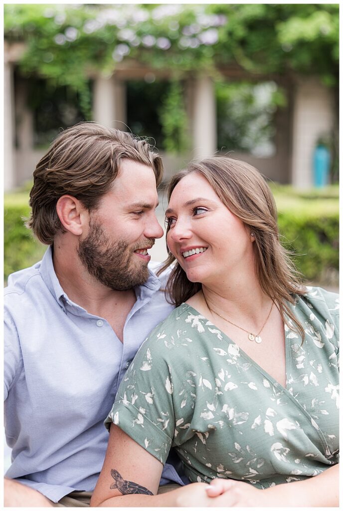 engaged couple looking at each other in Balboa park garden
