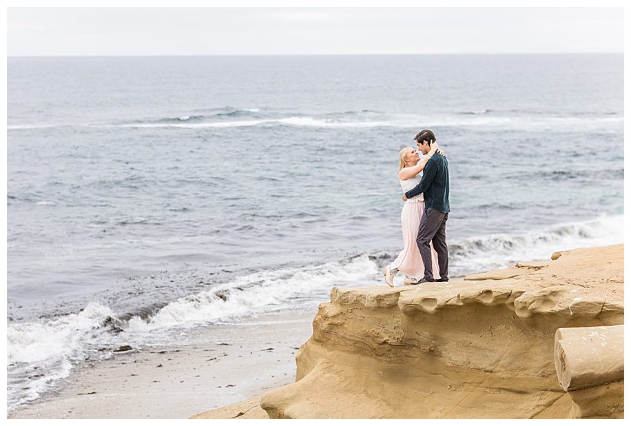 Couple standing on the edge of a cliff at their La Jolla Cliffs Engagement Session