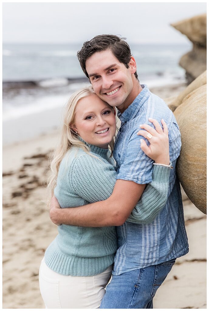 couple hugging on beach at their San Diego Engagement Session