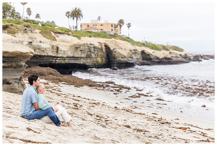 couple sitting on beach at their La Jolla Engagement Session