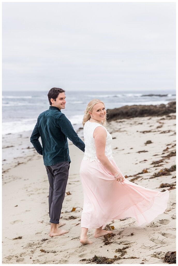 couple walking away down beach at their San Diego Engagement Session
