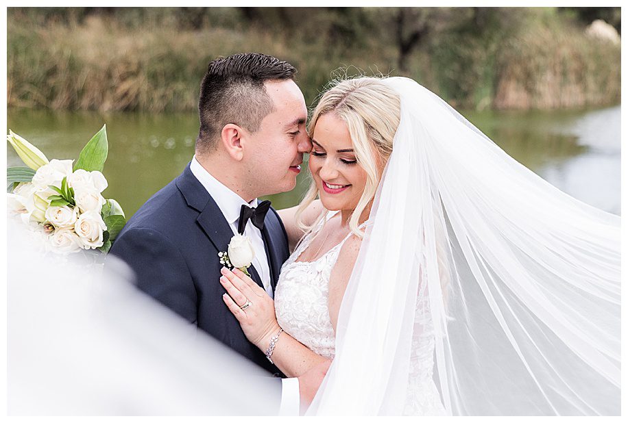 bride and groom hugging and flying veil at their WestWynd Ranch Wedding