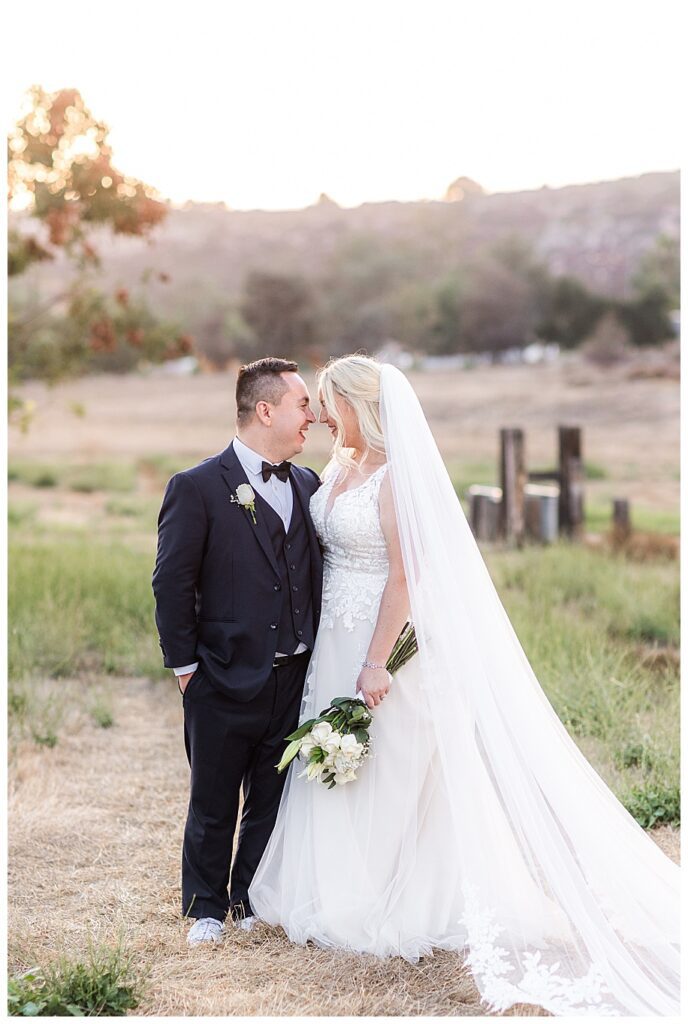 bride and groom standing in field at their WestWynd Ranch Wedding