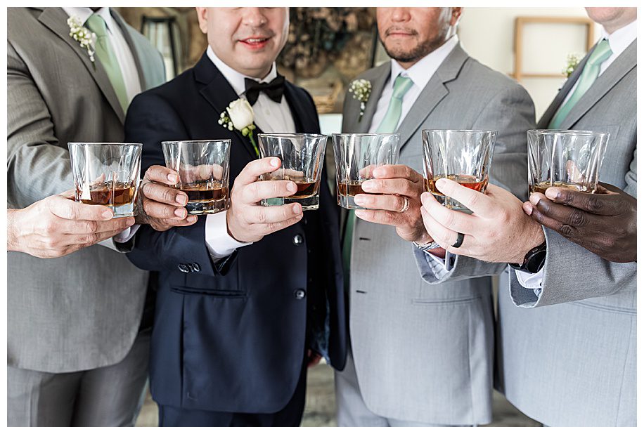 groom and groomsmen holding whiskey