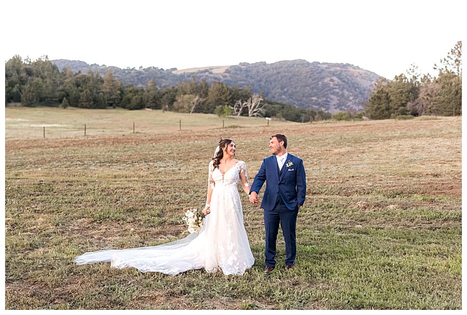 bride and groom standing in mountain field at their Sacred Mountain Wedding