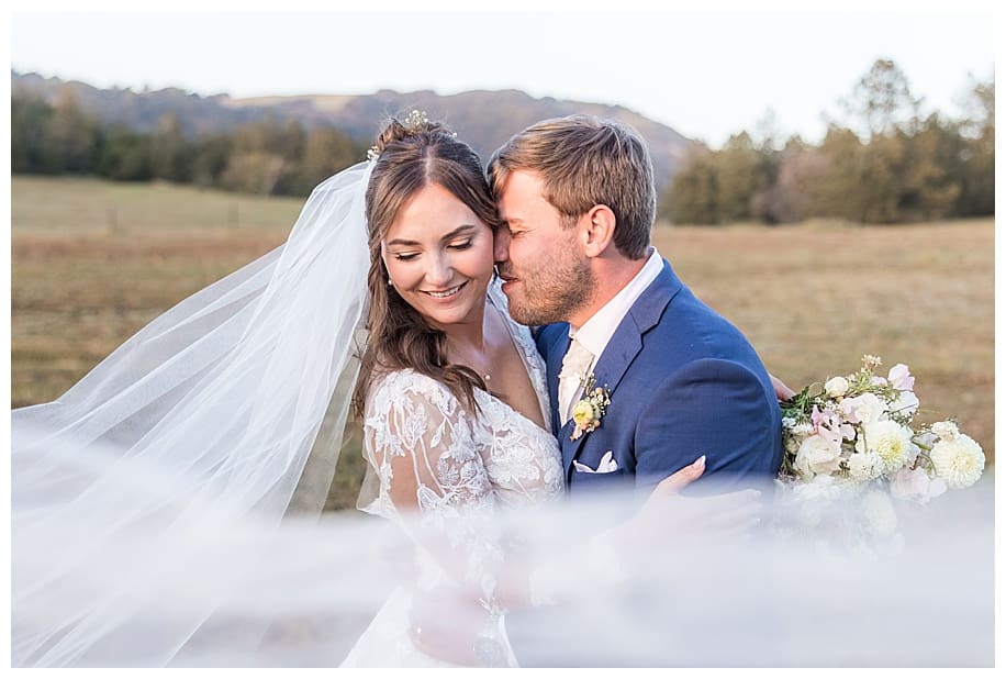 bride and groom snuggling and long veil at their Sacred Mountain Wedding