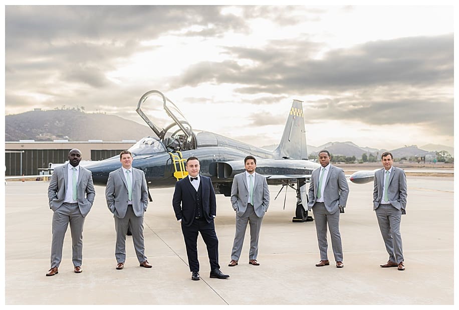 groom and groomsmen portrait session standing by jet