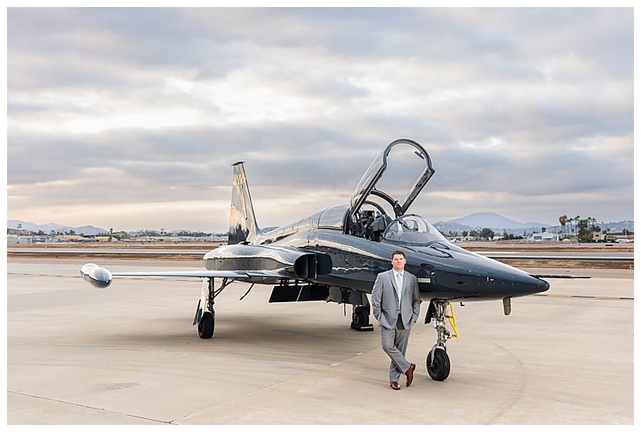 groom leaning against jet fighter