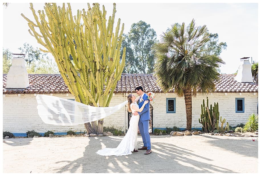 bride and groom standing in front of adobe at their Leo Carrillo wedding