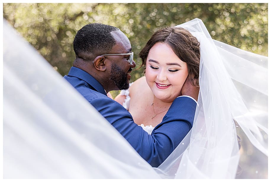 broom hugging bride with flying veil