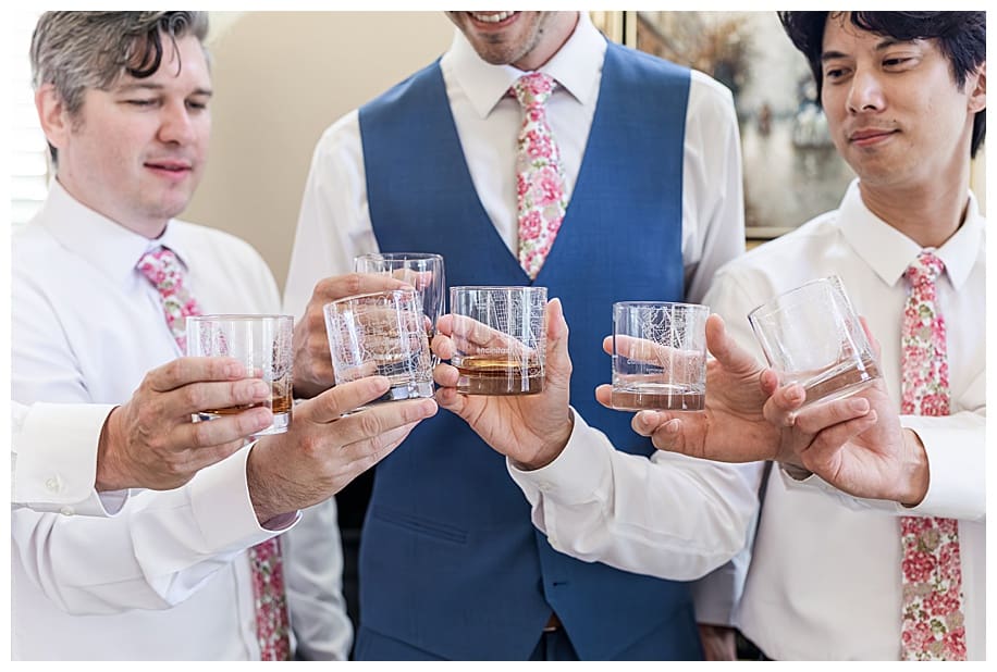 groom and groomsmen toasting with whiskey